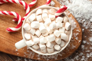 Noel atmosferi. Lezzetli kakao, marşmelov ve baston şeker, ahşap masa, üst manzara.