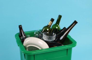 Çöpler açık mavi arka planda çöp kutusunda, yakın plan. Atık sıralama