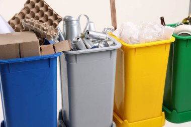 Çöp tenekeleri beyaz arka planda, yakın plan. Atık sıralama
