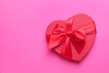 Sevgililer Günün kutlu olsun. Pembe arka planda kalp şeklinde hediye kutusu, üst manzara. Metin için boşluk