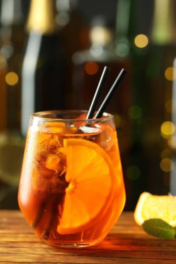 Sodalı kokteyl, nane ve portakal dilimleri bardaki ahşap masada, yakın plan.