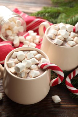 Marşmelovlu lezzetli kakao, baston şekerler ve ahşap masada Noel dekoru, yakın plan.