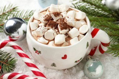 Marşmelovlu lezzetli kakao, baston şekerler ve yapay kar üzerine Noel dekoru, yakın plan.