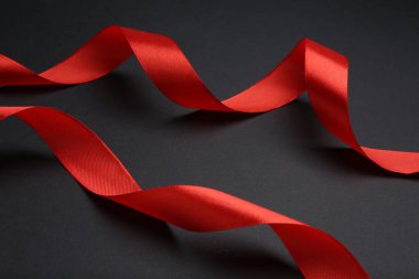 Koyu arkaplanda güzel kırmızı kurdeleler, yakın plan.