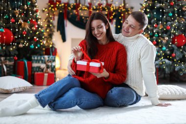 Evde Noel hediyesi olan mutlu çift.