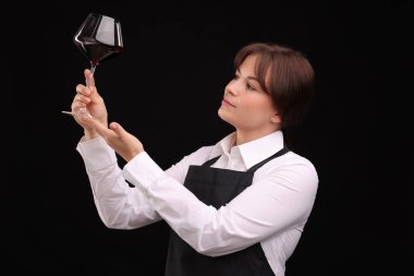 Siyah arka planda kırmızı şarap kadehi olan profesyonel şarap garsonu.