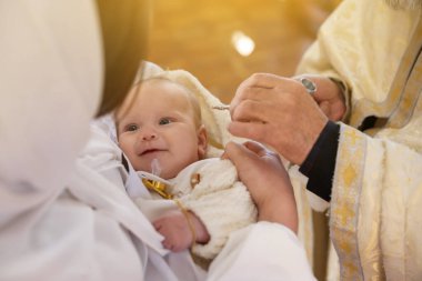 Kilisede vaftiz töreni düzenleyen rahip, yakın plan.