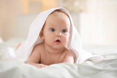 Beyaz havluyla sarılı şirin bir bebek. Kapalı bir odada, mesaj için yer var.