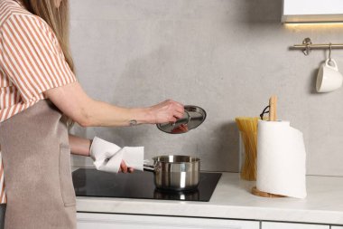 Mutfakta yemek yaparken kağıt havlu kullanan kadın, yakın plan.