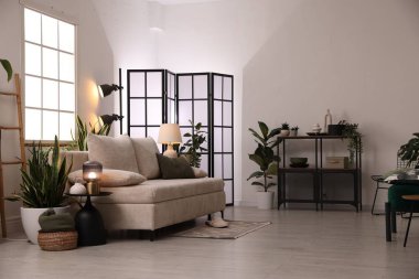 Kanepesi ve çiçekleri olan şık bir oturma odası. İç tasarım