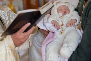 Kilisede vaftiz töreni düzenleyen rahip, yakın plan.
