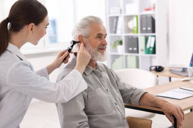 Duyma testi. Klinikte hastanın kulağını yıldız falıyla muayene eden doktor.