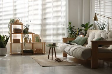 Kanepesi ve çiçekleri olan şık bir oturma odası. İç tasarım