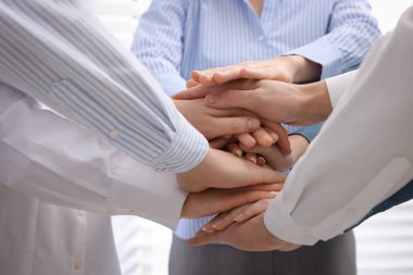 İçeride el ele tutuşan insanlar, yakın çekim. Takım oluşturma