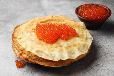 Gri masada kırmızı havyarlı leziz krepler, yakın plan.