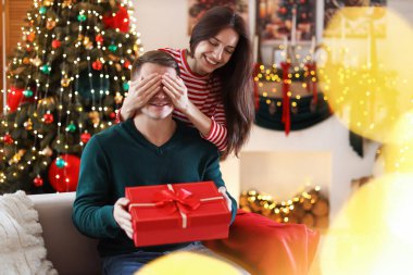 Mutlu kadın evde erkek arkadaşına yılbaşı hediyesiyle sürpriz yapıyor.