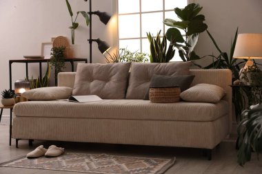 Kanepesi ve çiçekleri olan şık bir oturma odası. İç tasarım