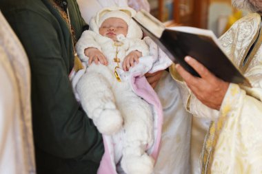 Kilisede vaftiz töreni düzenleyen rahip, yakın plan.