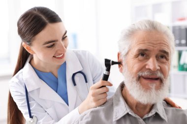 Duyma testi. Klinikte hastanın kulağını yıldız falıyla muayene eden doktor.