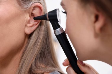 Duyma testi. Klinikte hastanın kulağını yıldız falıyla muayene eden doktor.