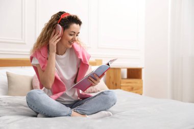 Evde beyaz duvarın yanında şarjörlü mutlu bir kadın var. Metin için boşluk