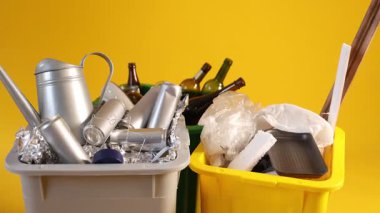 Çöp tenekeleri turuncu arka planda, kamera içeri giriyor. Atık sıralama