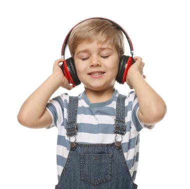 Kulaklıklı gülümseyen küçük çocuğun portresi beyaz arka planda müzik dinliyor.