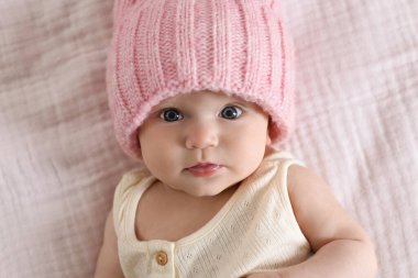 Yatakta örgü şapkalı, yeni doğmuş şirin bir bebek.