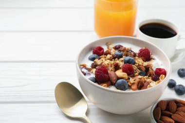 Sağlıklı kahvaltı. Fındıklı yulaf ezmesi, böğürtlen ve süt beyaz ahşap masada, yakın plan. Metin için boşluk