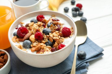 Sağlıklı kahvaltı. Fındıklı yulaf ezmesi, böğürtlen ve süt beyaz ahşap masada, yakın plan.