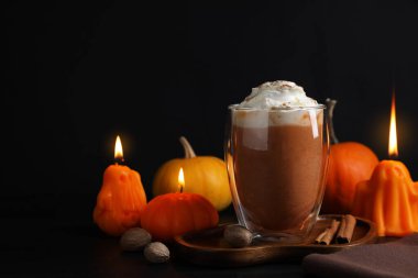Krem şantili balkabaklı latte ve siyah arka planda sonbahar dekoru, yakın plan. Metin için boşluk