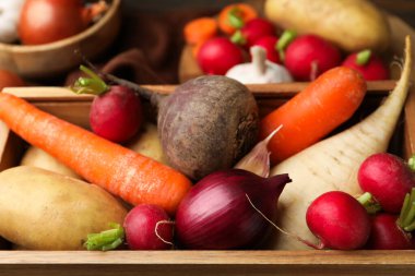 Tahta sandıkta farklı çiğ sebzeler, yakın plan.