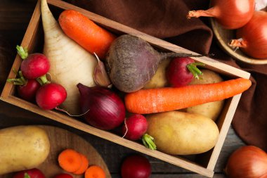 Tahta masada farklı çiğ sebzeler, düz uzanmış.