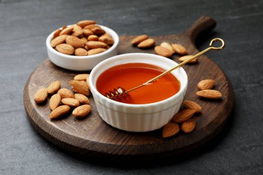 Lezzetli bal kasede ve bademler koyu dokulu masada, yakın plan