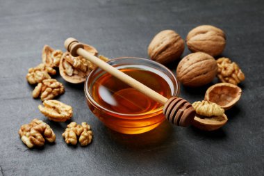 Cam kasede lezzetli bal ve koyu dokulu masada ceviz, yakın plan.