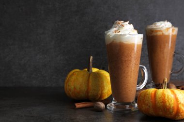 Krem şanti, baharat ve taze sebzeli balkabaklı latte, koyu dokulu masa, yakın plan. Metin için boşluk