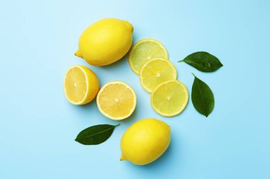 Taze olgun limonlar ve açık mavi arka planda yapraklar.