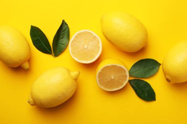 Taze olgun limonlar ve sarı arka planda yapraklar.