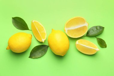 Taze taze limonlar ve açık yeşil arka planda yapraklar.