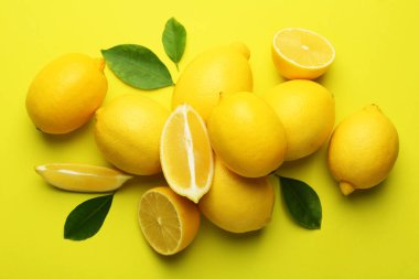 Taze olgun limonlar ve sarı arka planda yapraklar.