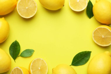 Taze olgun limonlardan yapılmış çerçeve ve sarı arka plandaki yapraklar düz. Metin için boşluk