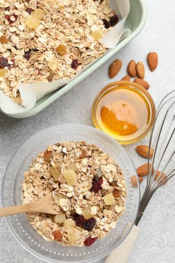 Tahıl yapıyorum. Yulaf ezmesi, kurutulmuş meyve, badem fıstığı ve balla bezenmiş düz bir kompozisyon.