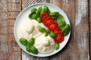 Tahta masada fesleğen ve domatesli nefis burata peyniri.