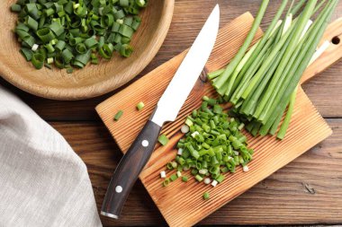 Tahta masada yeşil soğan ve bıçak kes, düz yat.