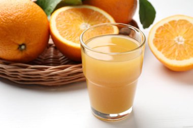 Taze portakal suyu ve beyaz masada meyveler, yakın plan.