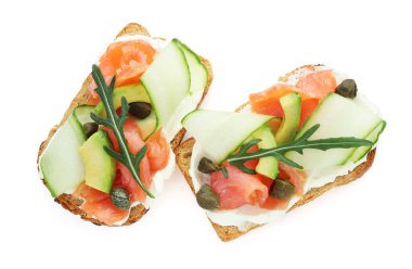 Somon, roka, avokado ve krem peynirli leziz bruschettalar beyaza izole edilmiş.