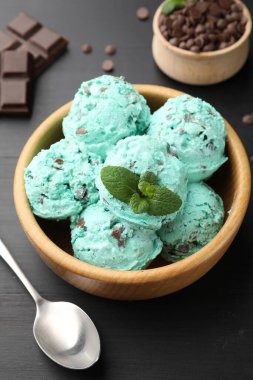 Siyah ahşap masada servis edilen naneli çikolatalı dondurma.