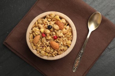 Kurumuş meyveli lezzetli granola ve siyah masada fındıklar.