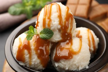 Karamel soslu lezzetli dondurma ve masada nane şekeri, yakın plan.