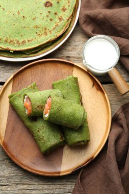 Tahta masada servis edilen somon ve krem peynirli ıspanaklı krep.